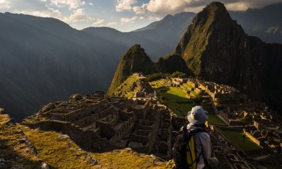 45568731 - machu picchu illuminated by the last sunlight. the inca's city is the most visited travel destination in peru. one person sitting in contemplation.