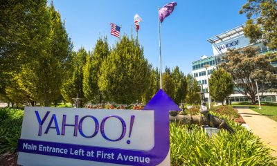 63408830 - sunnyvale, california, united states - august 15, 2016: flags in front of yahoo headquarters main entrance in sunnyvale with american flag and flag with yahoo icon.